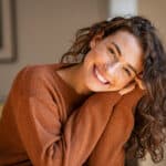 Portrait of comfortable woman in winter clothes relaxing on armchair