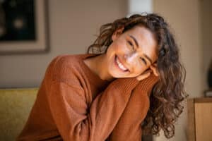 Portrait of comfortable woman in winter clothes relaxing on armchair