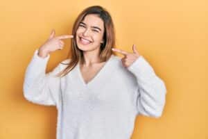 caucasian girl wearing casual clothes smiling cheerful showing and pointing with fingers teeth and mouth