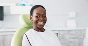 A woman smiling and sitting in a chair for a laser dentistry appointment