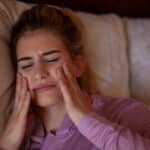 A woman with bruxism in Pasadena, TX, touching her jaw